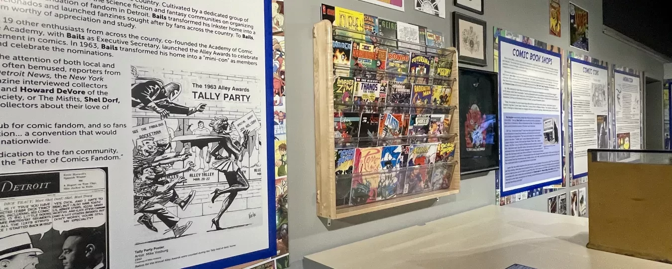 Exhibit wall with comic book memorabilia and historical panels in a museum setting.